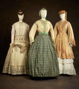 Links: Wandelkostuum à disposition, ca. 1870, katoen, glas en metaal, Kunstmuseum Den Haag Midden: Blouse, ca. 1845, zijde en wol, Rok, ca. 1860, zijde en katoen. Rechts:  Japon, ca. 1871-1872, linnen, Kunstmuseum Den Haag