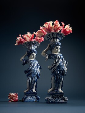 Bloemenhouders, Delft, plateelbakkerij De Metaale Pot, LVE-merk van eigenaar Lambertus van Eenhoorn (1691-1721), 1691-ca. 1700, tinglazuuraardewerk, hoogte 43,4 en 42,5 cm  Links: Kunstmuseum Den Haag – De Lavino Collectie Rechts: Kunstmuseum Den Haag, aankoop 2024 met steun van Fonds Kunstmuseum  Fotograaf: Mounir Raji  Met dank aan Holex Flower voor de levering van de papegaai tulpen van kweker Jos Blom uit Avenhorn.